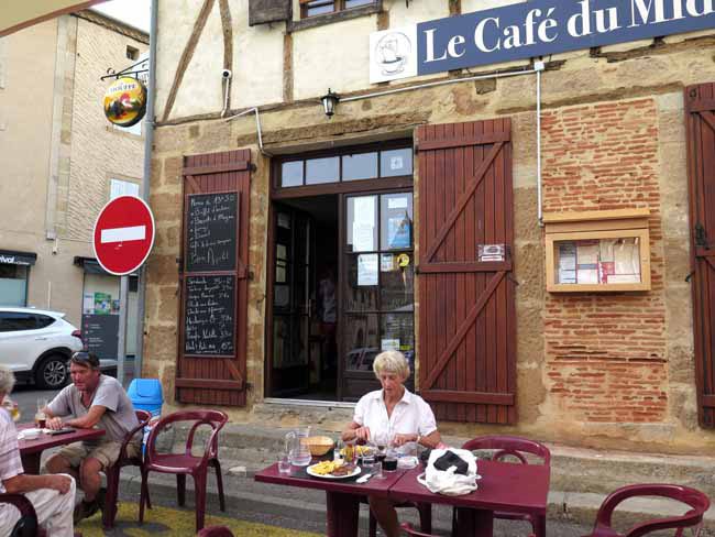 Walking in France: The half-timbered Café du Midi (with our benefactor to the left)