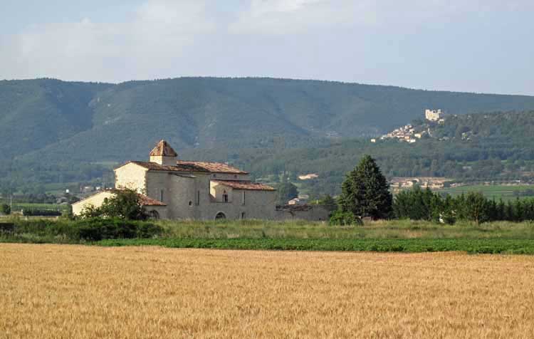 Walking in France: Passing a farmhouse, with the perched village of Lacoste in the background
