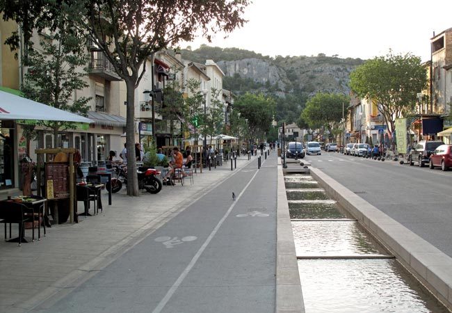 Walking in France: Looking along the Rue Gambetta to the grey cliffs of the Colline St-Jacques