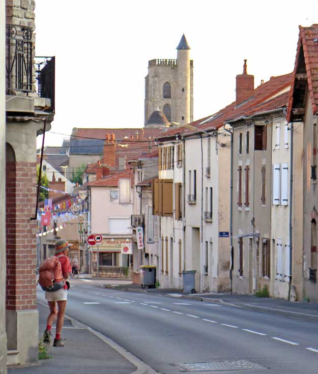 Walking in France: Heading back to the bar for breakfast, with the impressive clock tower looming over the town